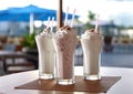 Milkshakes with strawberry,chocolate and vanilla with whipped cream on cafe table.Macro.AI Generative