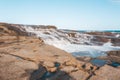 Milky ocean cascades flowing over honey coloured rocks