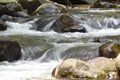 milky water flowing through stones