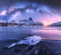 Milky Way above frozen sea coast and snow covered mountains