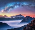 Milky Way above mountains in fog at night in summer Royalty Free Stock Photo