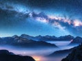 Milky Way above mountains in fog at night in summer