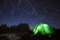 Milky way above the mountains with tent