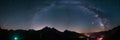 Milky Way arc and stars in night sky over the Alps. Outstanding Comet Neowise glowing at the horizon on the left. Panoramic view, Royalty Free Stock Photo