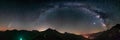 Milky Way arc and stars in night sky over the Alps. Outstanding Neowise Comet glowing at the horizon on the left. Panoramic view,