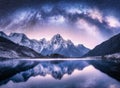 Milky Way arch over snowy mountains and lake at night Royalty Free Stock Photo