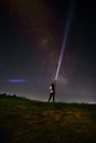 Beautiful night sky with stars and silhouette of a standing alone woman on the mountain with a lantern. Blue milky way Royalty Free Stock Photo