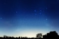 Blue dark night sky with many stars above field of trees. Milky way cosmos background. Space landscape.