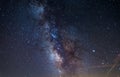 Milky way galaxy core and jupiter planet glowing in a bright starry night sky. Christmas background, astronomy, star gazing Royalty Free Stock Photo