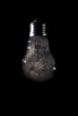 Milky Way galaxy inside of light bulb on dark background Royalty Free Stock Photo