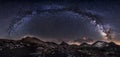 Milky Way galaxy and mountain peaks panorama.