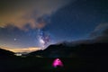 Milky way galaxy stars over the Alps, camping illuminated tent, Mars and Jupiter planet, snowcapped mountain range, astro night Royalty Free Stock Photo