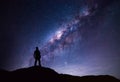 Milky Way landscape. Silhouette of Happy man standing on top of mountain with night sky and bright star on background Royalty Free Stock Photo