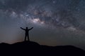 Milky Way landscape. Silhouette of Happy man standing on top of mountain with night sky and bright star on background Royalty Free Stock Photo