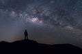 Milky Way landscape. Silhouette of Happy man standing on top of mountain with night sky and bright star on background Royalty Free Stock Photo