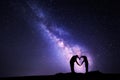 Milky Way. Man and woman holding hands in heart shape