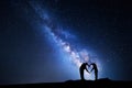 Milky Way. Man and woman holding hands in heart shape