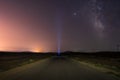 Milky Way on night sky and standing man silhouette on road with flashlight . Colorful night landscape. Exploring the universe