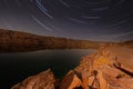 Milky Way over a lake in a granite quarry at night. Summer landscape with huge boulders, trees, purple sky with milky Royalty Free Stock Photo