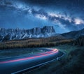 Milky Way over mountain road. Blurred car headlights Royalty Free Stock Photo