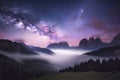 Milky Way over mountains in fog at night in summer. Landscape with foggy alpine mountain valley Royalty Free Stock Photo