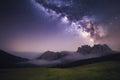 Milky Way over mountains in fog at night in summer. Landscape with foggy alpine mountain valley Royalty Free Stock Photo