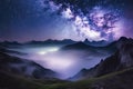 Milky Way over mountains in fog at night in summer. Landscape with foggy alpine mountain valley Royalty Free Stock Photo