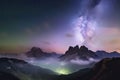 Milky Way over mountains in fog at night in summer. Landscape with foggy alpine mountain valley Royalty Free Stock Photo