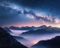 Milky Way over mountains in fog at night in summer