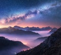 Milky Way over mountains in fog at night in summer. Landscape Royalty Free Stock Photo