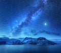 Milky Way over snow covered mountains and sea at night in winter Royalty Free Stock Photo