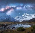 Milky Way over snowy mountains and lake at night. Landscape Royalty Free Stock Photo
