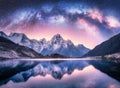 Milky Way over snowy mountains and lake at night