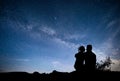 Milky Way with silhouette of people. Landscape with night starry sky. Standing man and woman on the mountain with star Royalty Free Stock Photo