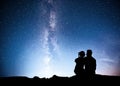 Milky Way with silhouette of people. Landscape with night starry sky. Standing man and woman on the mountain with star Royalty Free Stock Photo