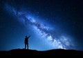Milky Way. Silhouette of a standing man pointing finger in night starry sky on the mountain Royalty Free Stock Photo