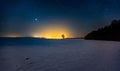 Milky way and starry sky over winter landscape and distant village Royalty Free Stock Photo