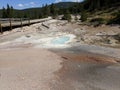 Milky white blue pool next to walkway at Yellowstone National Park