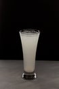 Milky white drink in clear glass. Alcoholic or non alcoholic drink on dark background with copy space