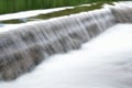 Milky white river flood torrent over concrete barrier