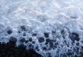 A milky white tide breaking on the rocky shore