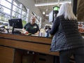 Mill Creek, WA USA - circa June 2022: View of an older woman unloading her shopping cart at the checkout lane inside Town and