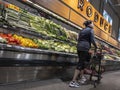 Mill Creek, WA USA - circa May 2022: Angled view of a person shopping for vegetables inside the produce department of a Town and