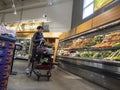 Mill Creek, WA USA - circa May 2022: Angled view of a person shopping for vegetables inside the produce department of a Town and