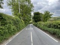 Mill Lane, with green hedgerow, and distant hills in, Hawksworth, Leeds, UK Royalty Free Stock Photo