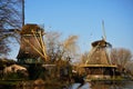 Mill traditionally made of wood along a river in the Netherlands. Old-fashioned way of collecting wind energy. Royalty Free Stock Photo