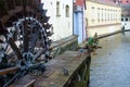 Mill Wheel of Velkoprzhevorskaya Mill and statue of Czech Water Kabourek on Chertovka River in Prague, Czech Republic