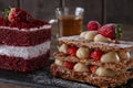 Mille feuille dessert sweet slice red velvet cake with white frosting is garnished with strawberries Royalty Free Stock Photo