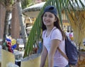 Millenial asian girl wearing a cap and backpack with backgound of coconut leaf and coconut tree Royalty Free Stock Photo