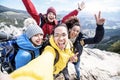 Millenial friends taking selfie on the top of the mountain - Young people on a hiking trip celebrate reaching the summit